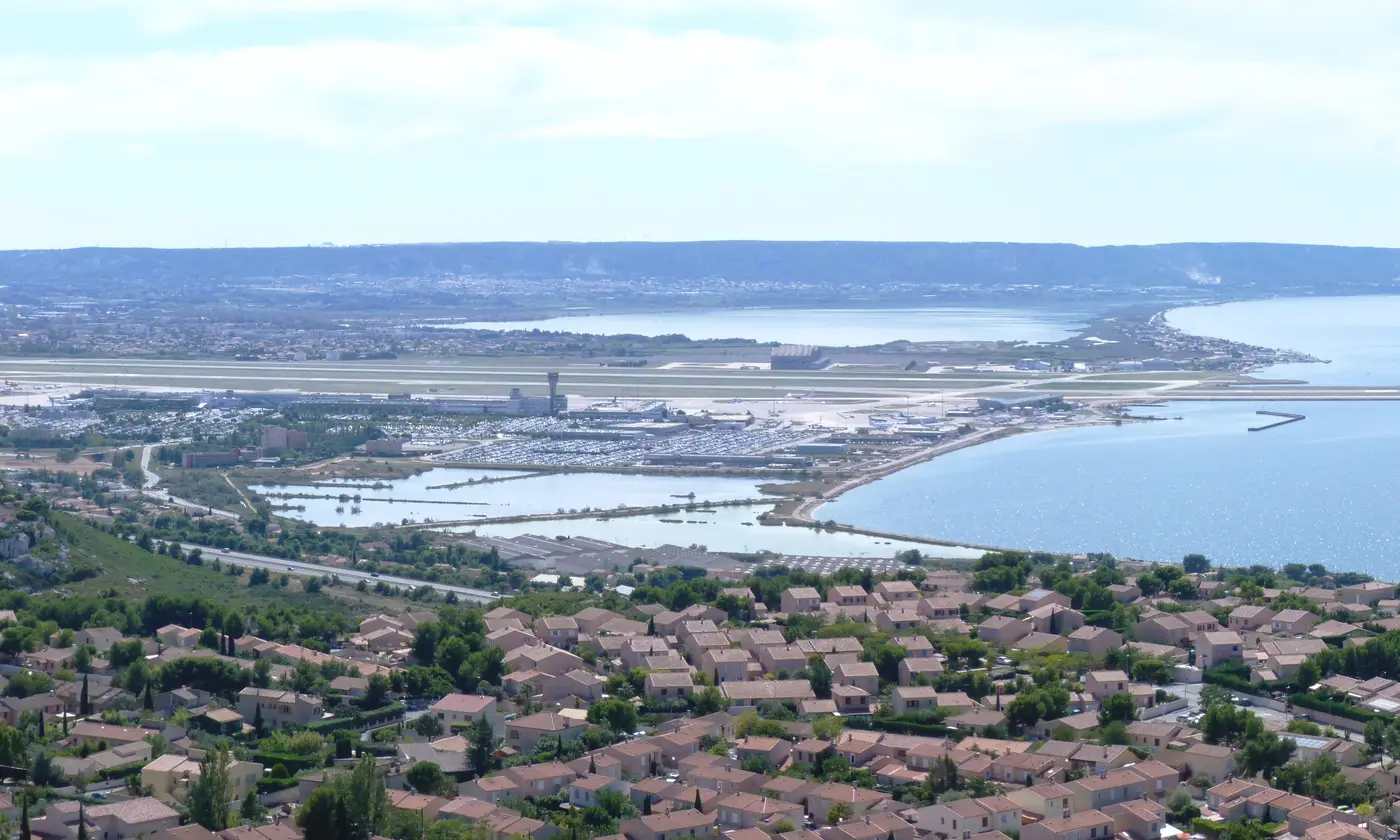 Les toits de Marignane, l'autoroute vers Marseille, les pistes de l'aéroport et l'étang de Berre vus depuis les hauteurs de Vitrolles.
