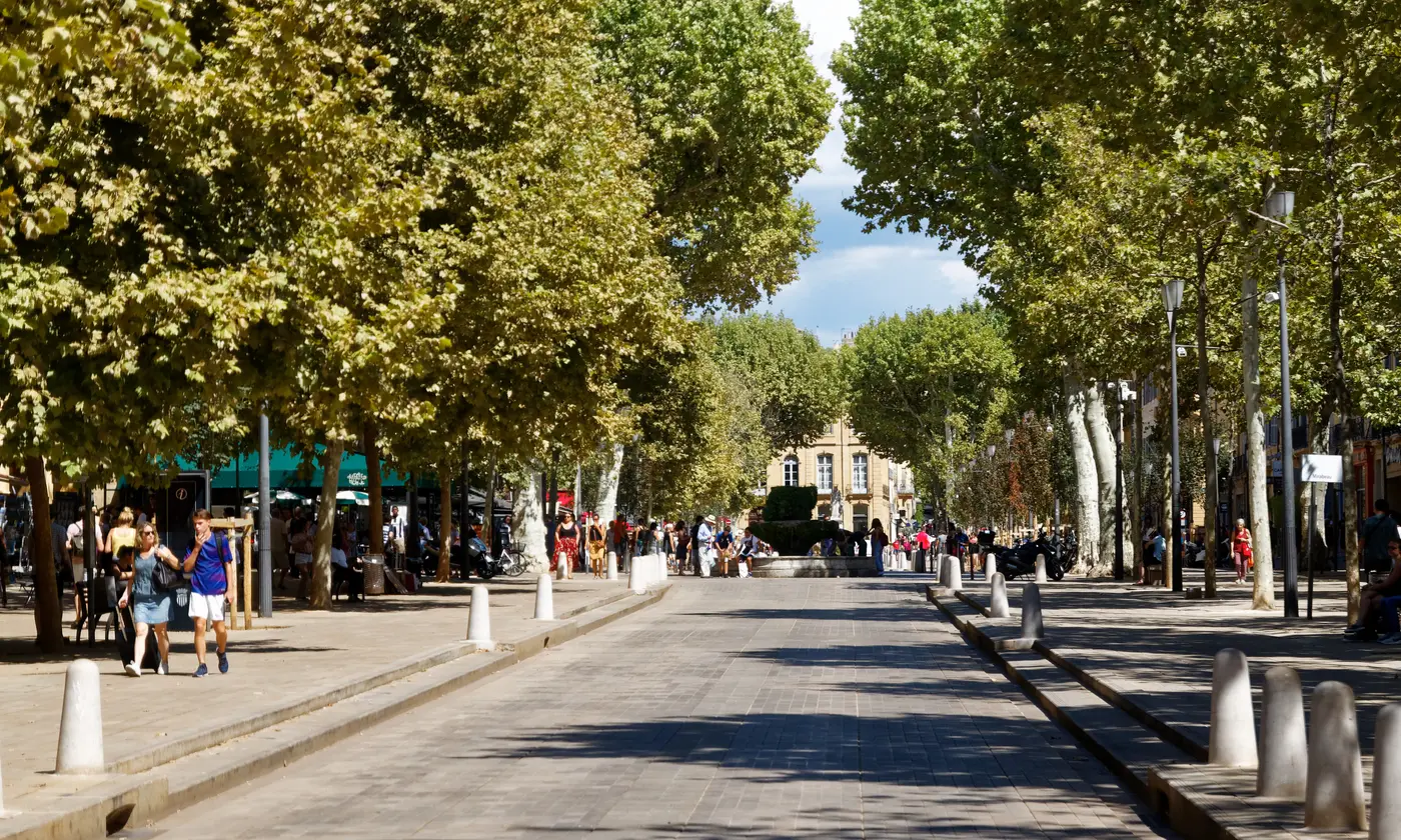 Le cours Mirabeau à Aix-en-Provence sous la voûte des platanes, avec la fontaine moussue et les façades au loin