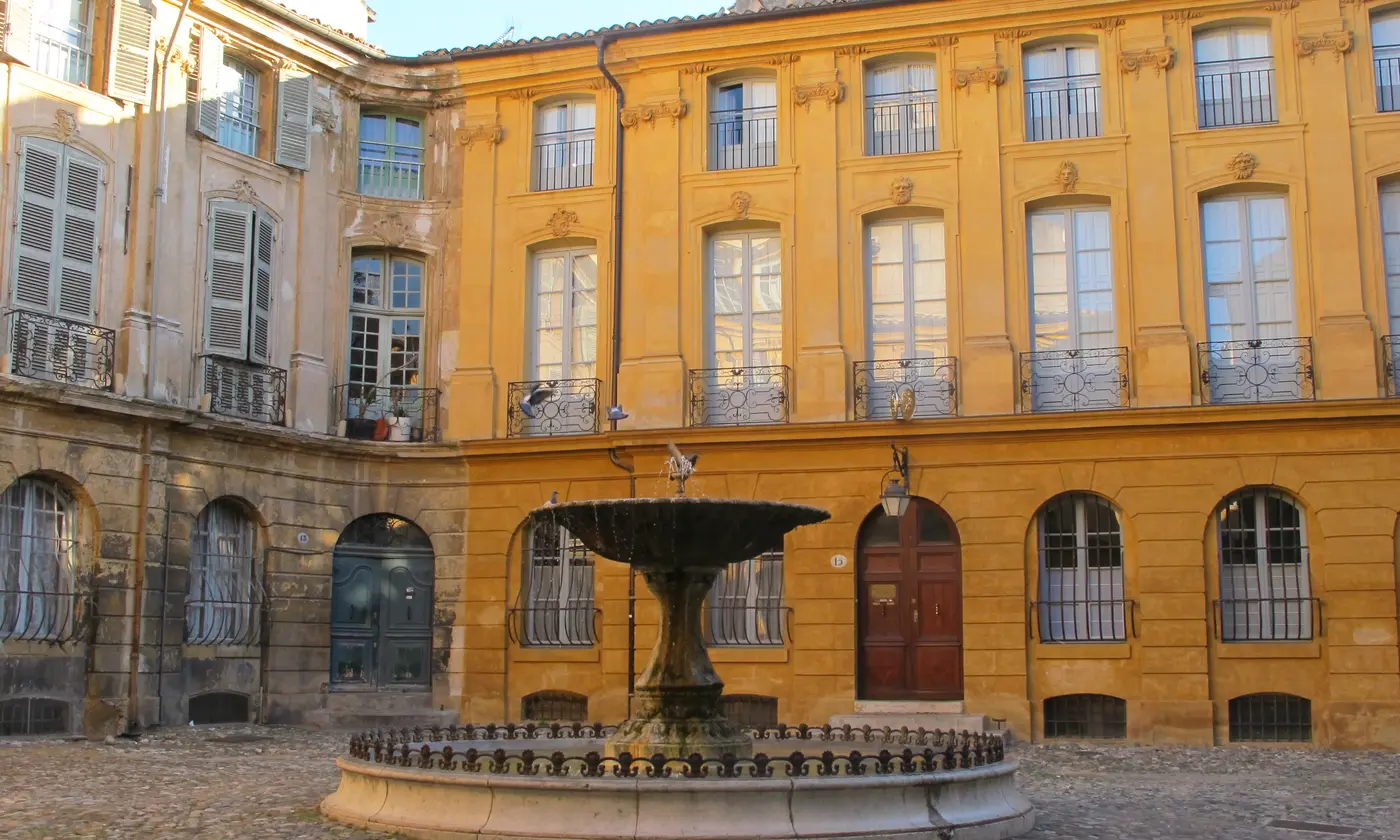 La place d'Albertas et sa fontaine au cœur du vieil Aix, façades baroques dorées par le soleil