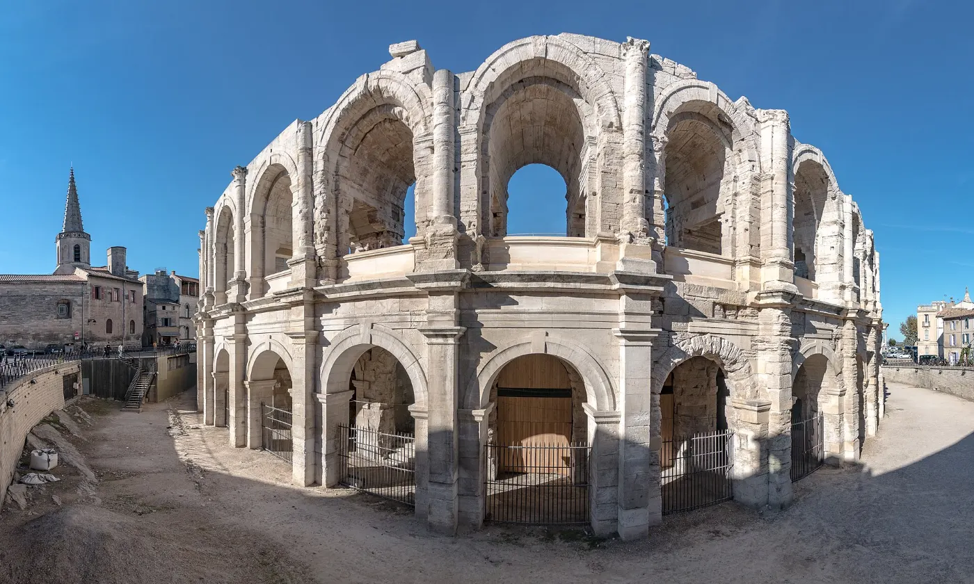 Les arènes romaines d'Arles et leurs deux étages d'arcades sous un ciel bleu
