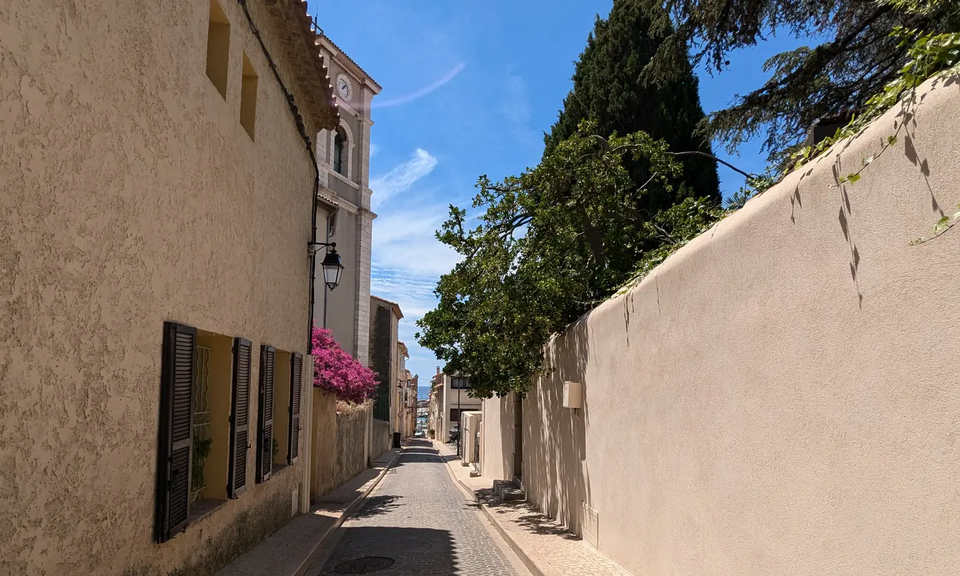 Ruelle provençale de la rue Frédéric-Mistral avec le clocher de l'église, un bougainvillier en fleurs et la mer en contrebas, Cassis