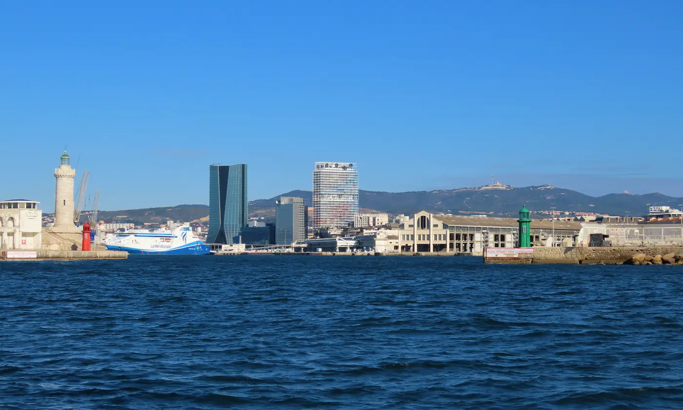 L'entrée du port de Marseille vue de la rade : phare Sainte-Marie, digues et balises, tours CMA CGM et La Marseillaise