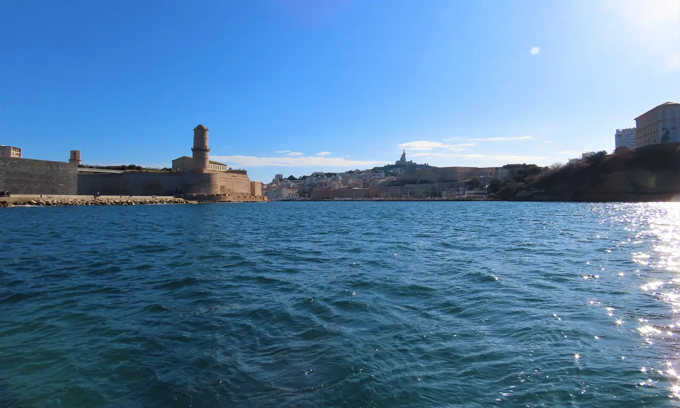 L'entrée du Vieux-Port de Marseille vue de la mer, avec le fort Saint-Jean et Notre-Dame de la Garde à l'horizon