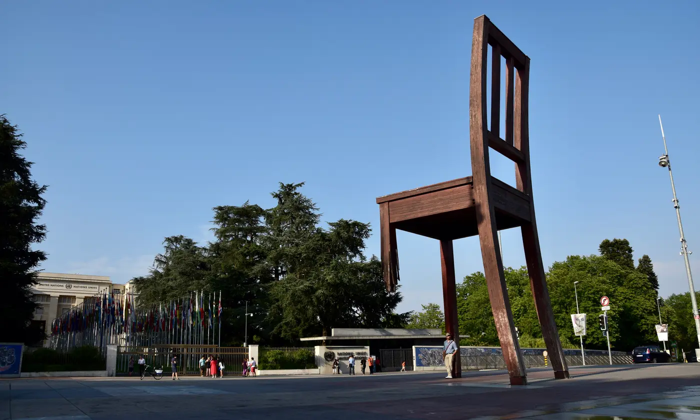 La sculpture Broken Chair sur la place des Nations, devant l'allée des drapeaux du Palais des Nations, Genève