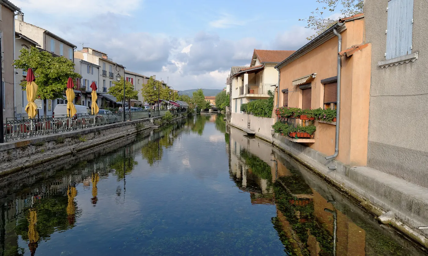 Canal de la Sorgue bordé de façades colorées à L'Isle-sur-la-Sorgue, reflets dans l'eau claire