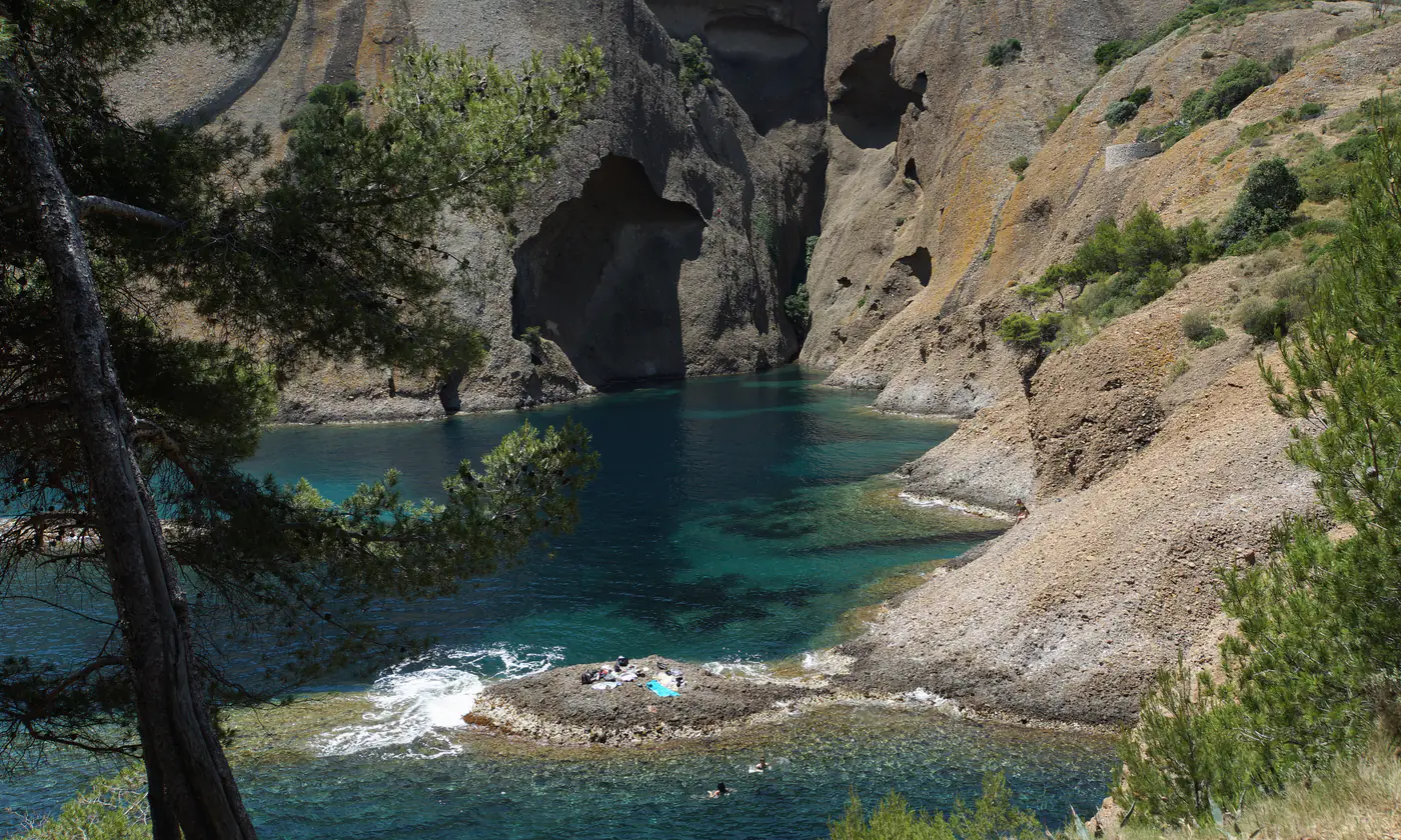 Crique aux eaux turquoise entre les falaises de poudingue, au pied du parc du Mugel, La Ciotat