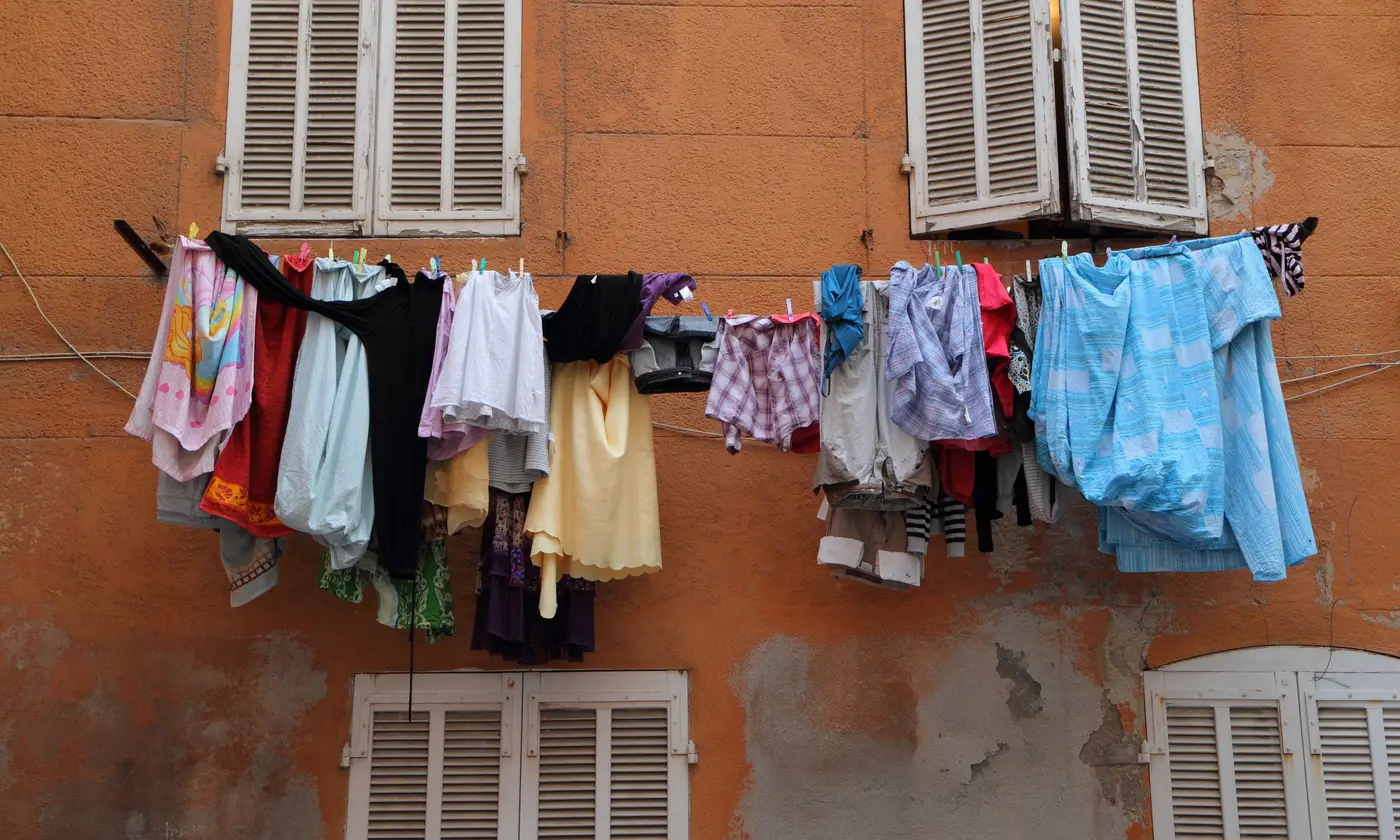 Linge coloré séchant sur une façade ocre aux volets anciens dans le quartier du Panier.