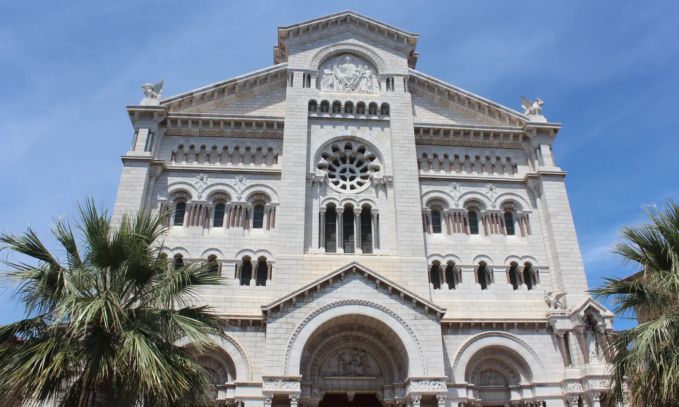Façade blanche de la cathédrale Notre-Dame-Immaculée encadrée de palmiers sous le ciel bleu, Monaco