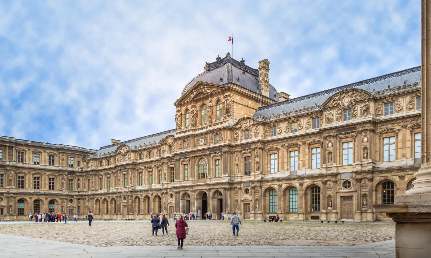 La Cour Carrée du palais du Louvre et son pavillon de l'Horloge sous un ciel bleu, Paris