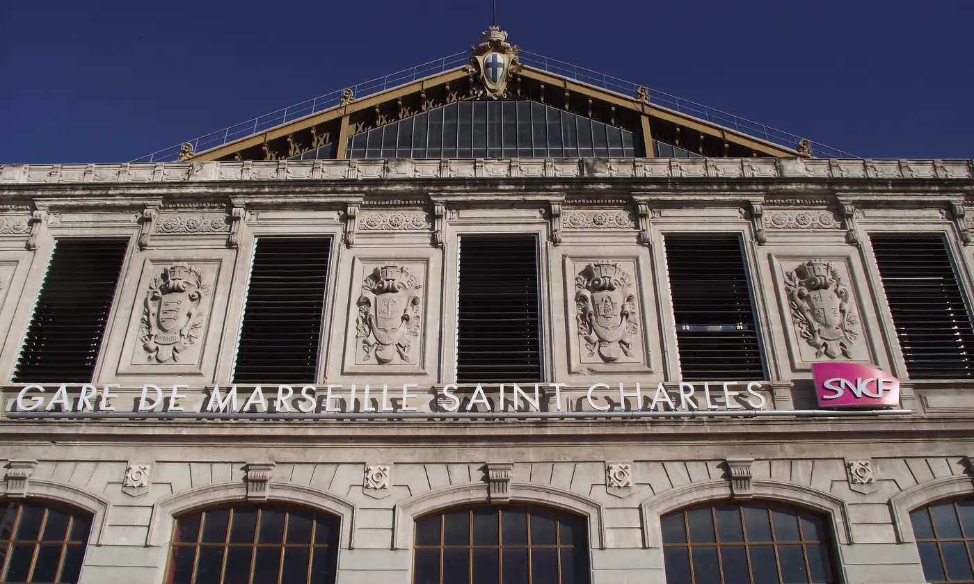 La facade de la gare de Marseille Saint-Charles, son enseigne monumentale et les blasons sculptes sous la verriere de la halle.