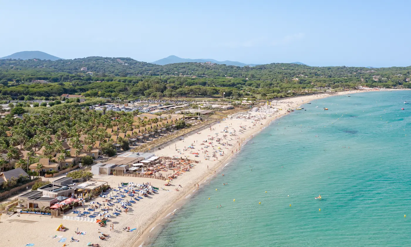 Vue aérienne de la plage de Pampelonne, sable clair et eau turquoise bordés de pinède, Saint-Tropez